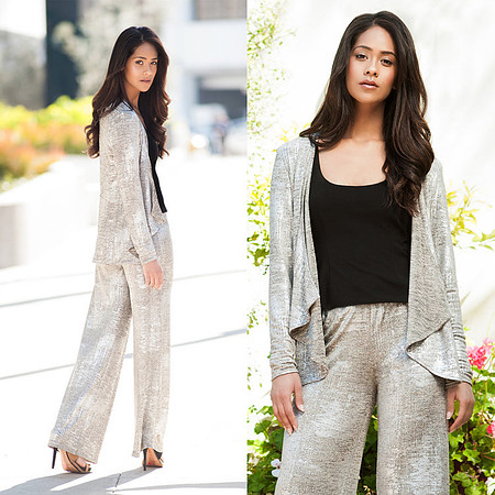 Full-length fashion portrait of a woman wearing a light gray relaxed suit outdoors.