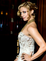 Close editorial portrait of a blonde woman in a white formal dress photographed in profile.