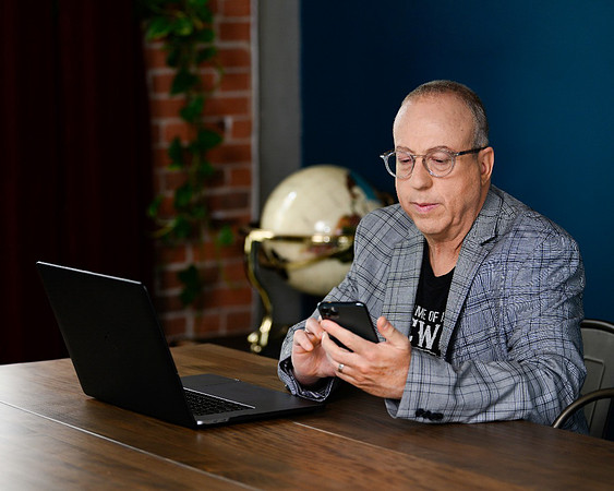 male-professional-using-smartphone-and-laptop-los-angeles