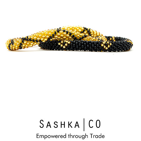 Product photograph of black and gold beaded bracelets on a white background with Sashka Co branding.