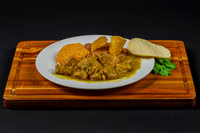 Commercial food photograph of a plated meat dish with rice, beans, tortillas, and cilantro.