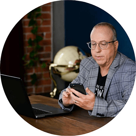 Professional branding image of the Technolene founder using a smartphone beside a laptop in an office setting.