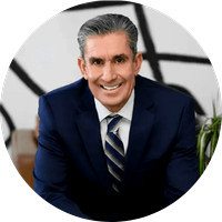 Professional branding portrait of business consultant and leadership coach Sean Caughron in a navy suit.