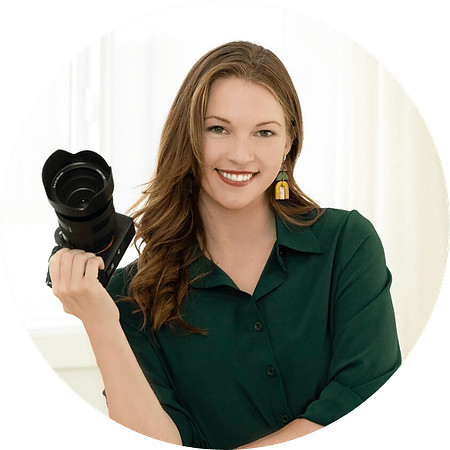 Professional branding portrait of a photographer holding a camera, created for the Ashley Blackmer Photography website project.