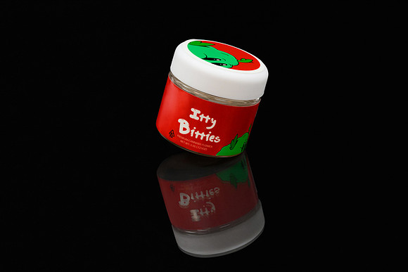Dark studio product photograph of a red Itty Bitties cannabis flower jar with a reflective surface.