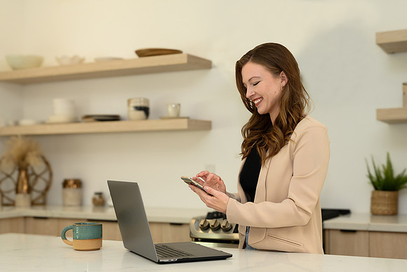 woman-using-smartphone-beside-laptop-los-angeles