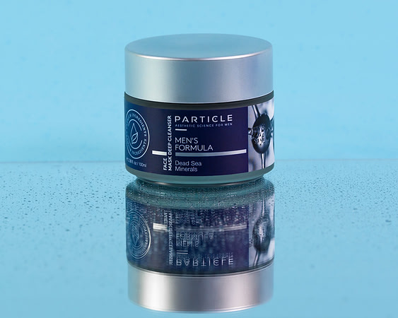 Skincare product photograph of a Particle men’s face mask jar on a reflective blue surface.